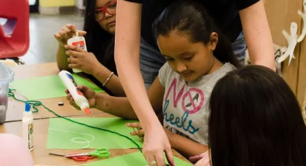 Youth creating art with support from a staff.